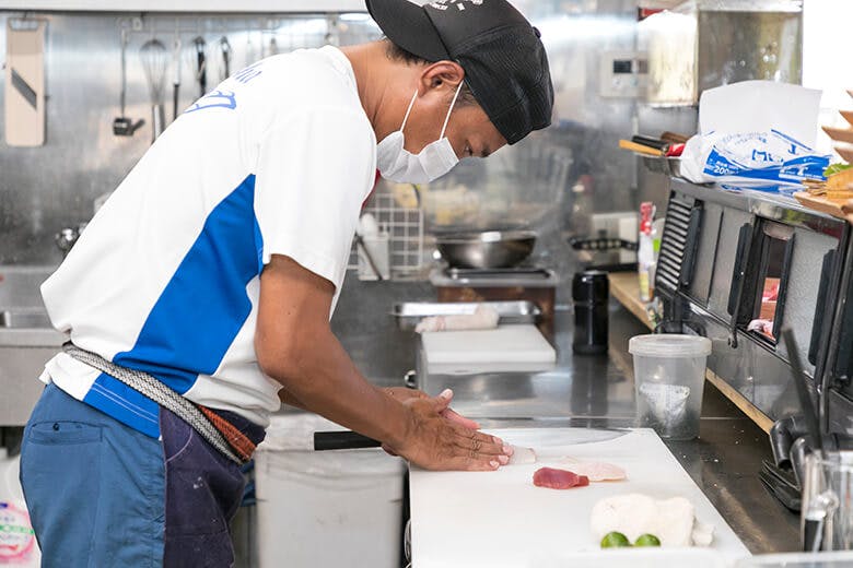 国頭港食堂(くにがみみなとしょくどう)|さくから刺身を切り出す男性