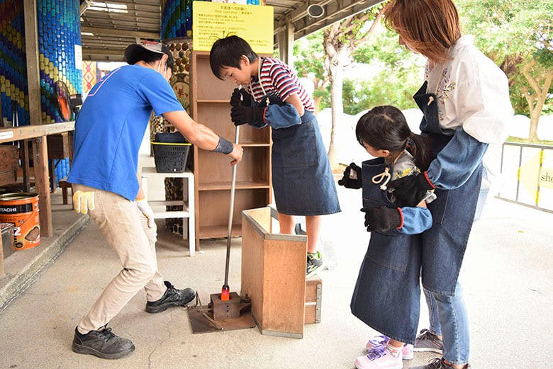 琉球ガラス村|ガラス吹き体験をする小学生ぐらいの男の子と家族