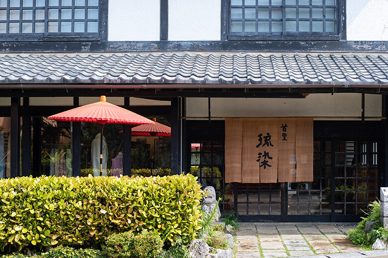 首里琉染｜暖簾と野点傘が趣のある店舗入り口
